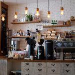 Coffee Shop - black kitchen appliance on kitchen island with pendant lights