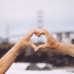 City Attractions - couple forming heart using their hands in focus photography