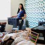 Sustainable Packing - woman in blue sleeveless dress sitting on bed