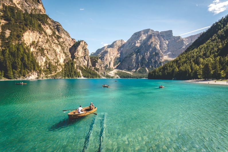 Green Travel - three brown wooden boat on blue lake water taken at daytime