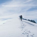 Mountain Climbing - two person climbing on mountain covered snow